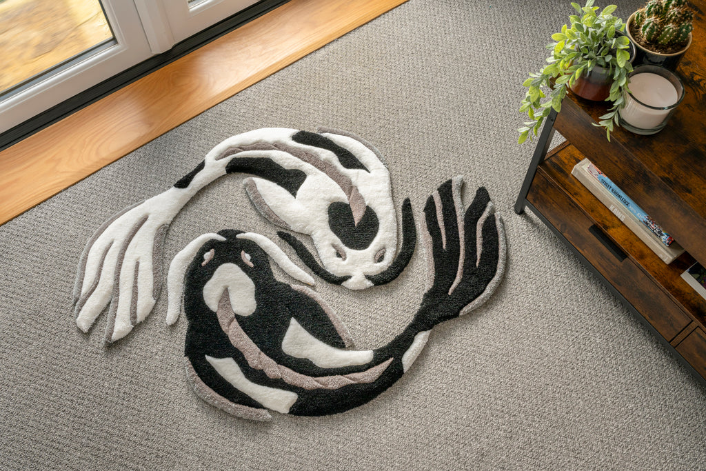 Two handmade black and white koi fish rugs arranged in a yin yang formation, inspired by traditional Japanese koi symbolism.