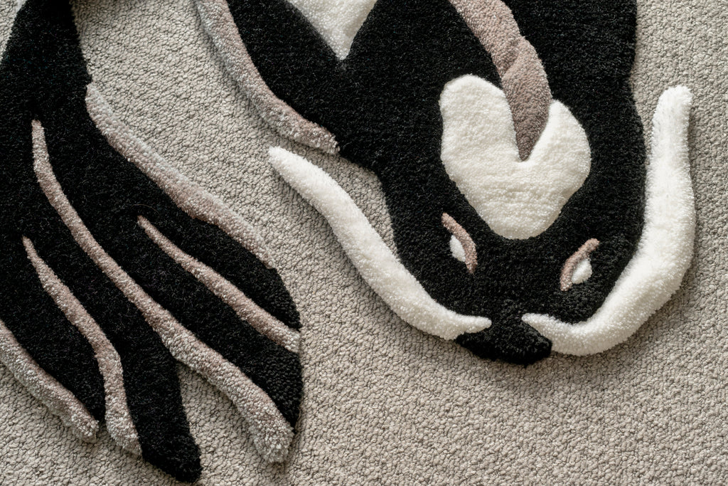Close-up of a handmade black and white koi fish rug showing sculpted carving, premium tufting and intricate detailing.