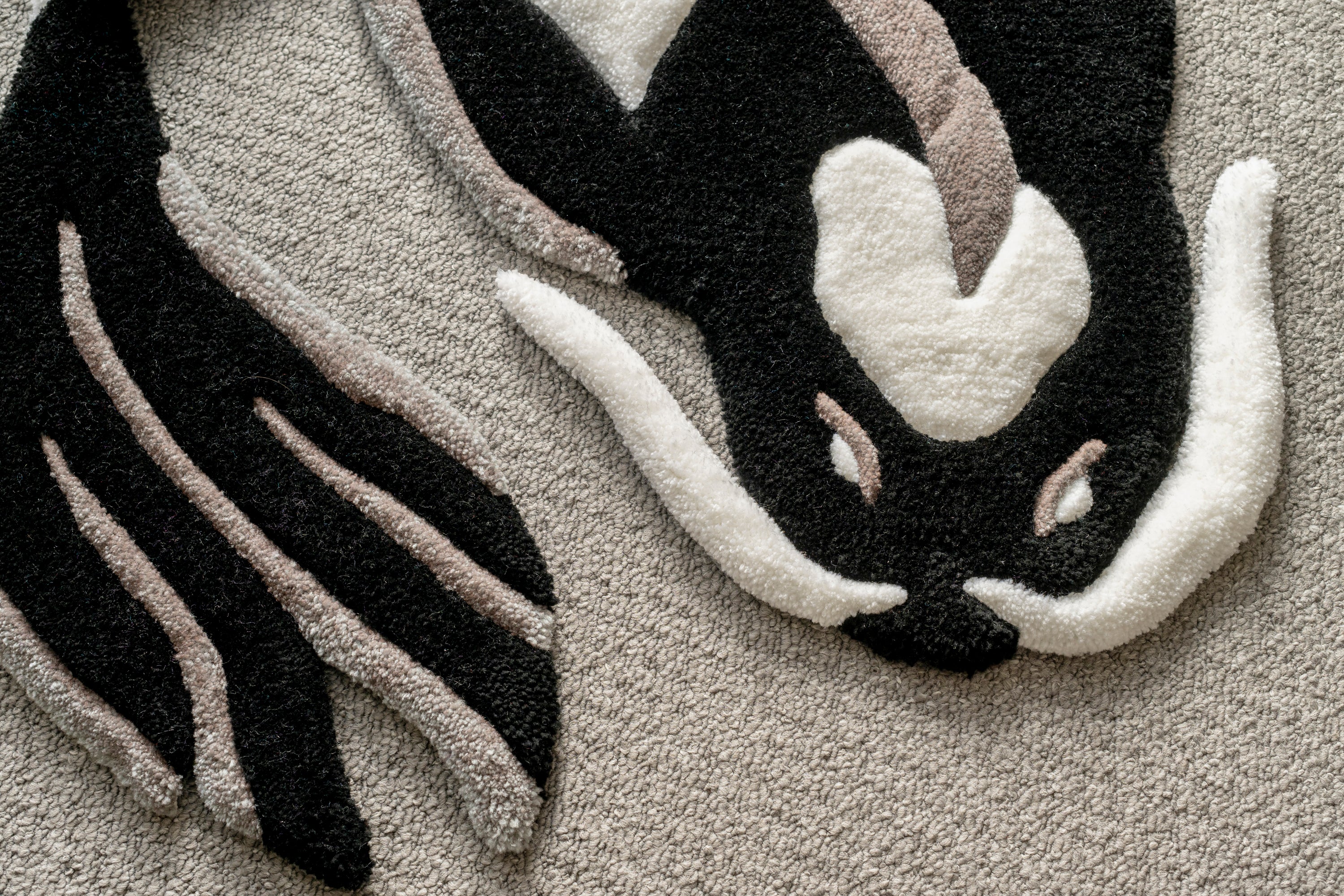 Close-up of a handmade black and white koi fish rug showing sculpted carving, premium tufting and intricate detailing.