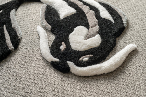 Detailed texture shot of a black and white koi fish rug crafted from soft acrylic yarn with a smooth low-pile finish.