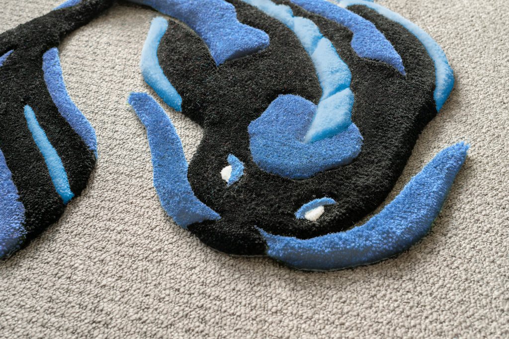 Detailed texture shot of a blue koi fish rug highlighting soft acrylic yarn, low-pile construction and handcrafted quality.