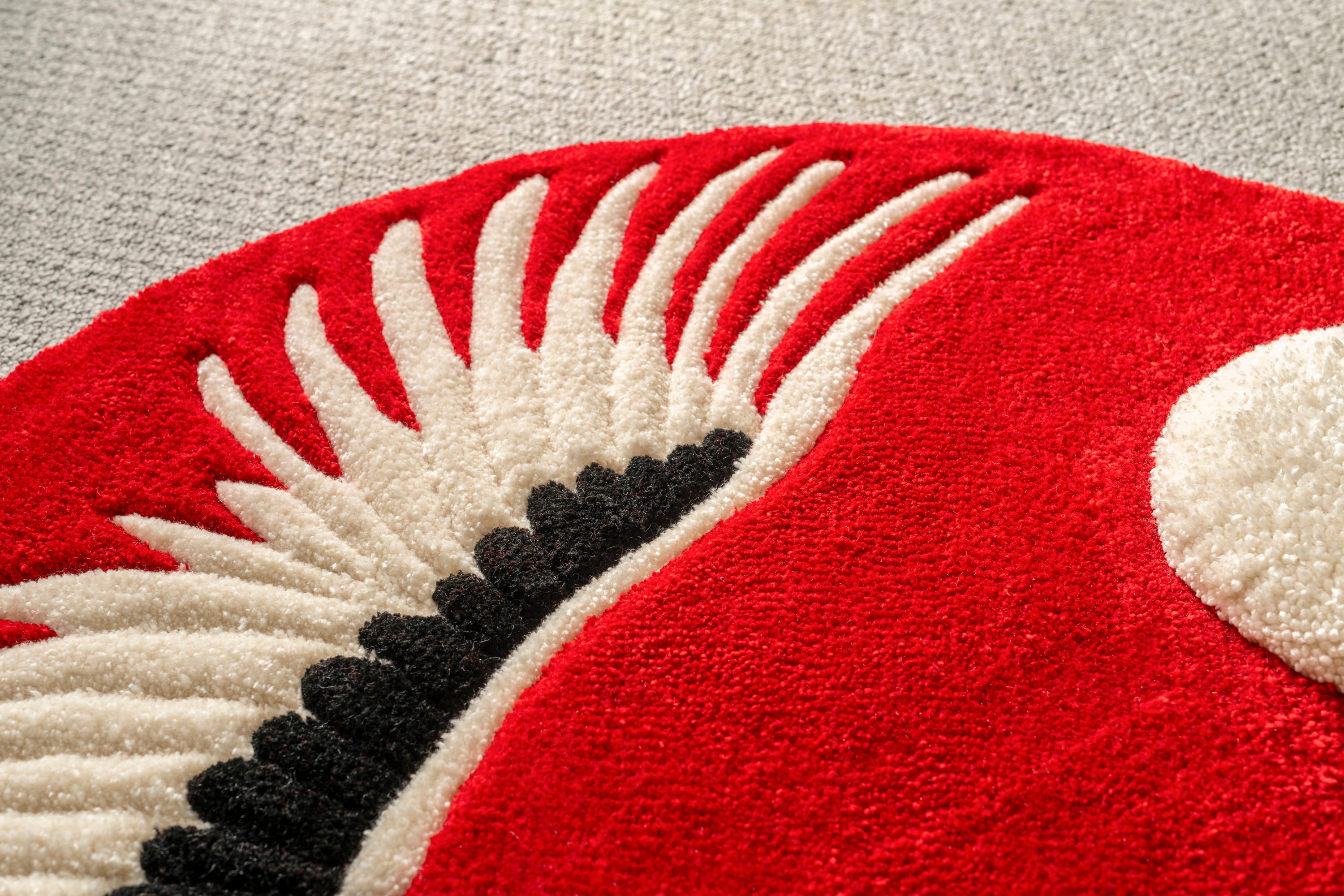 Close-up showing the textured feather detailing and craftsmanship of the handmade crimson crane rug.