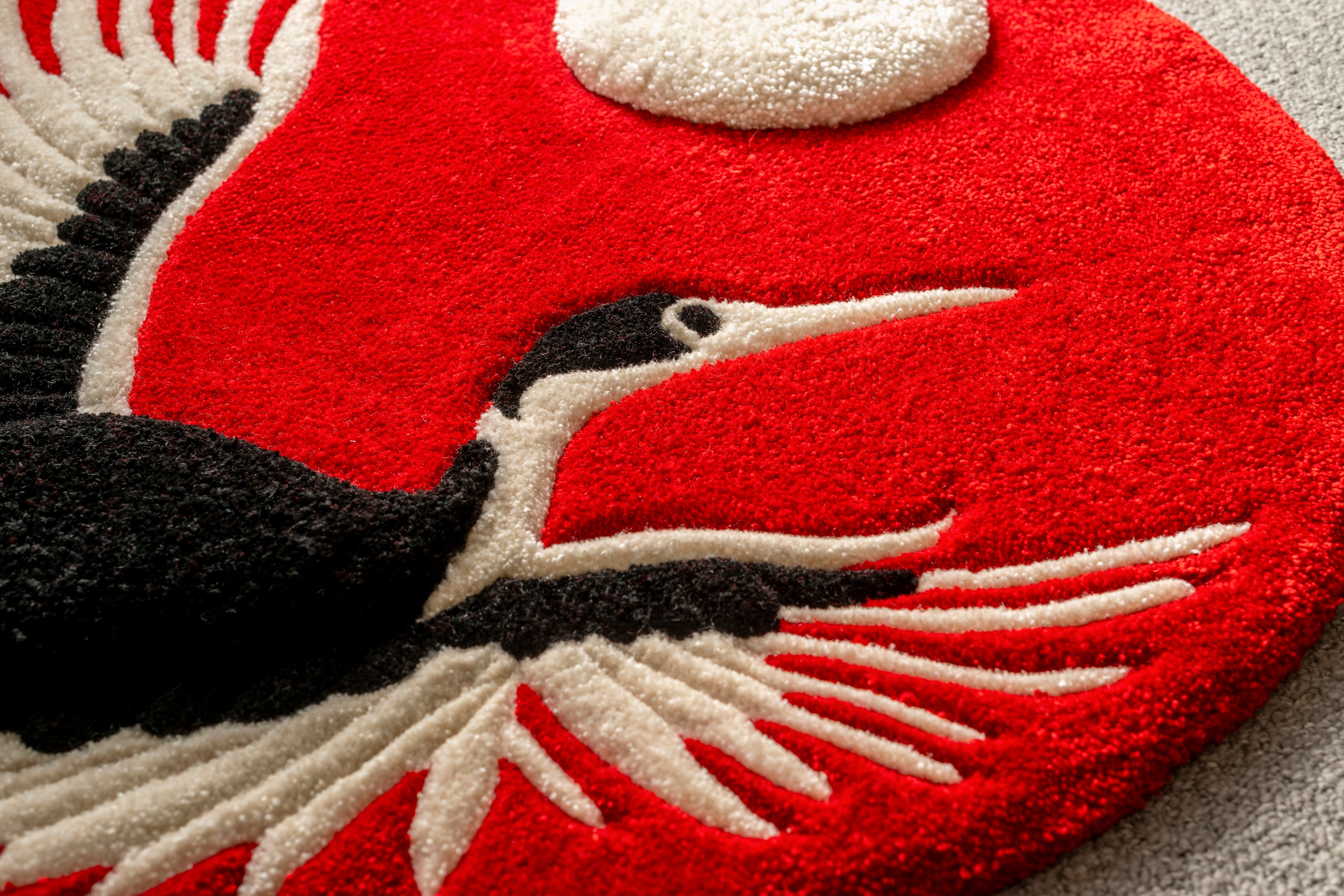 Detailed view of the crane and raised moon element on a handmade Japanese-inspired crane rug.