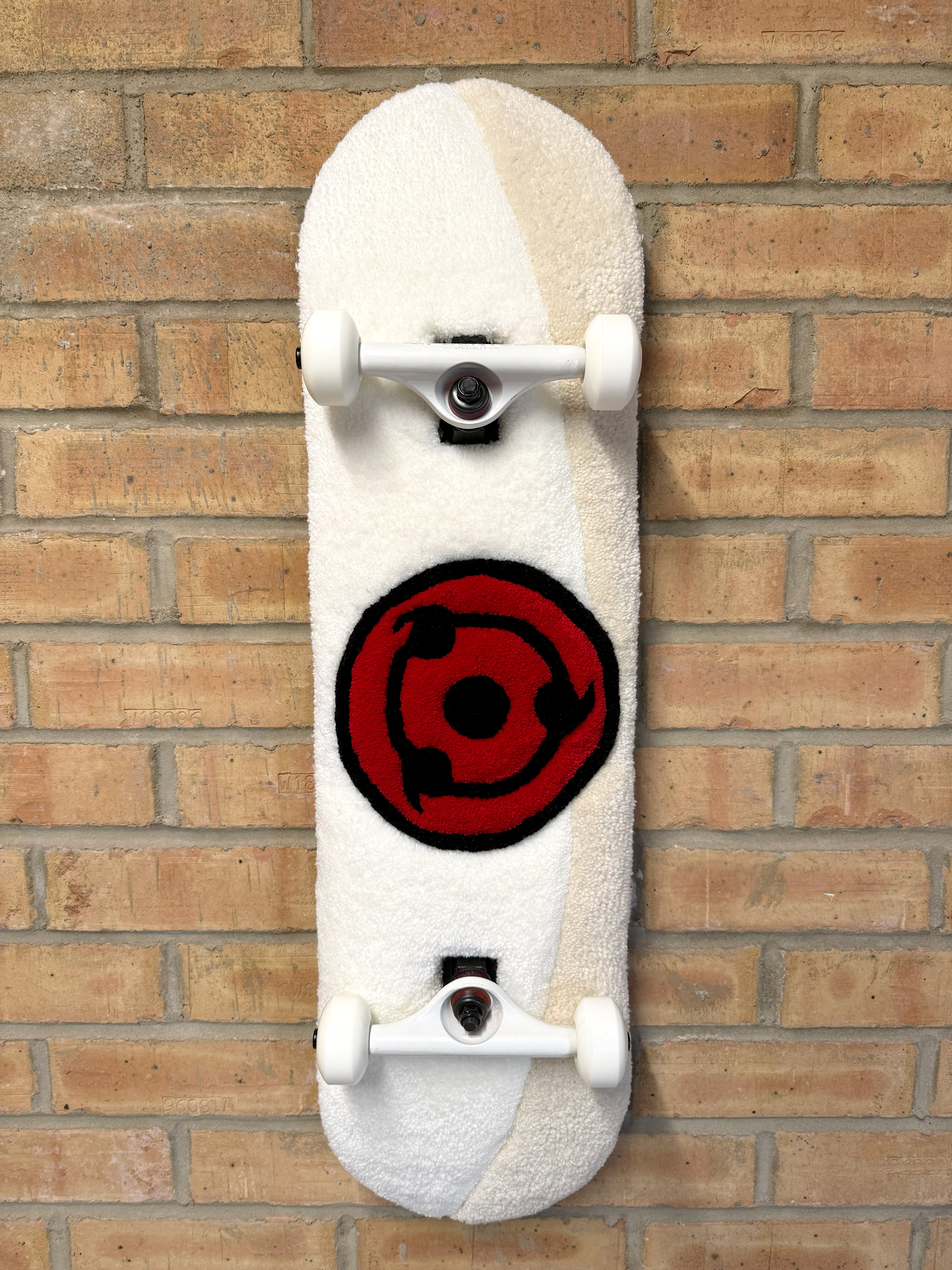 Handmade Crimson Eye Rugboard mounted on a skateboard deck featuring a bold red eye design on a white tufted background