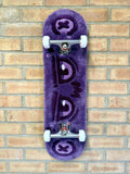 Full view of the Dirty Look Rugboard featuring a purple tufted eye design mounted on a complete skateboard deck with trucks and wheels.