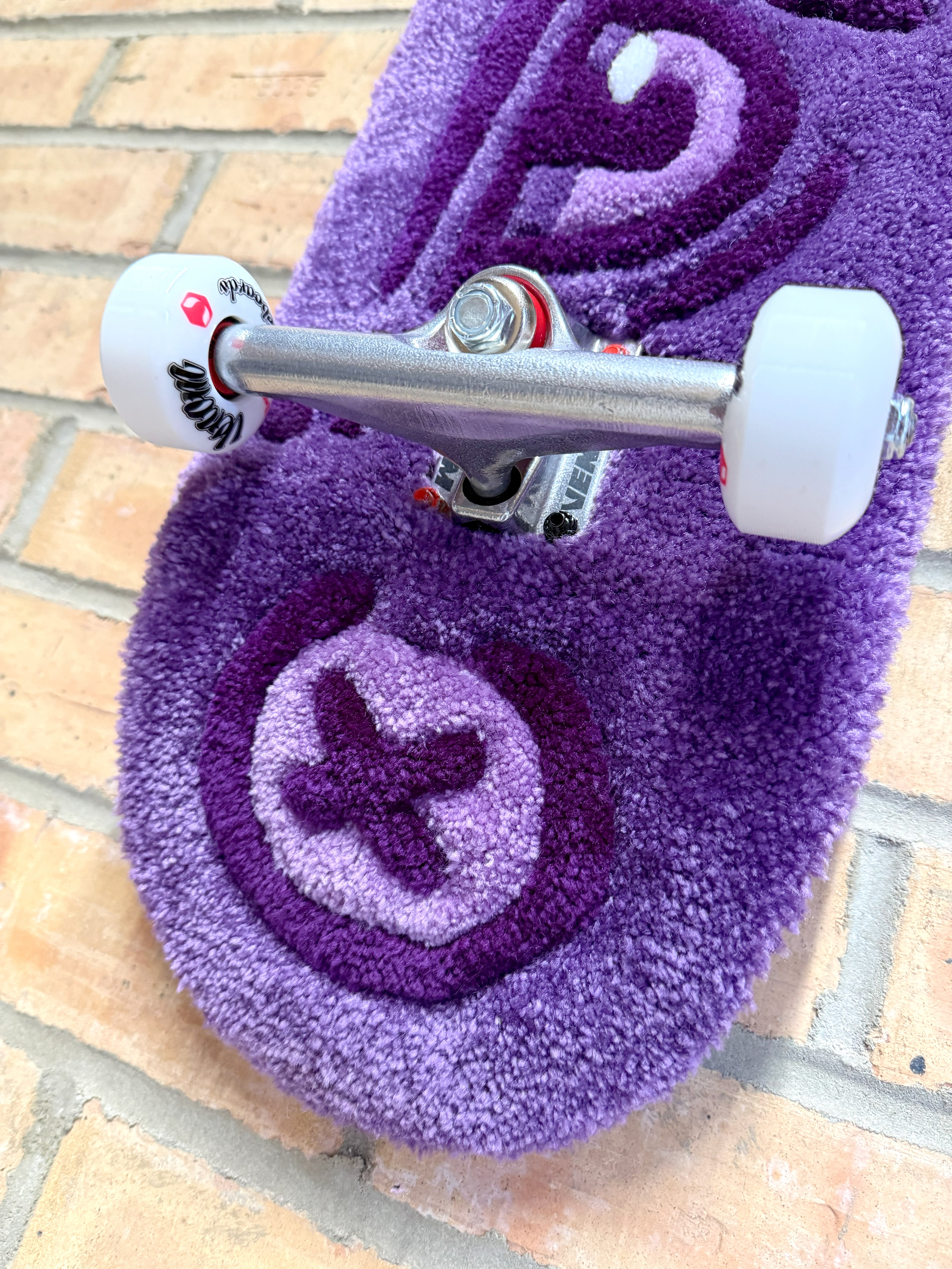 Close-up of the tail section of the Dirty Look Rugboard highlighting the handcrafted tufted texture and decorative skateboard construction.