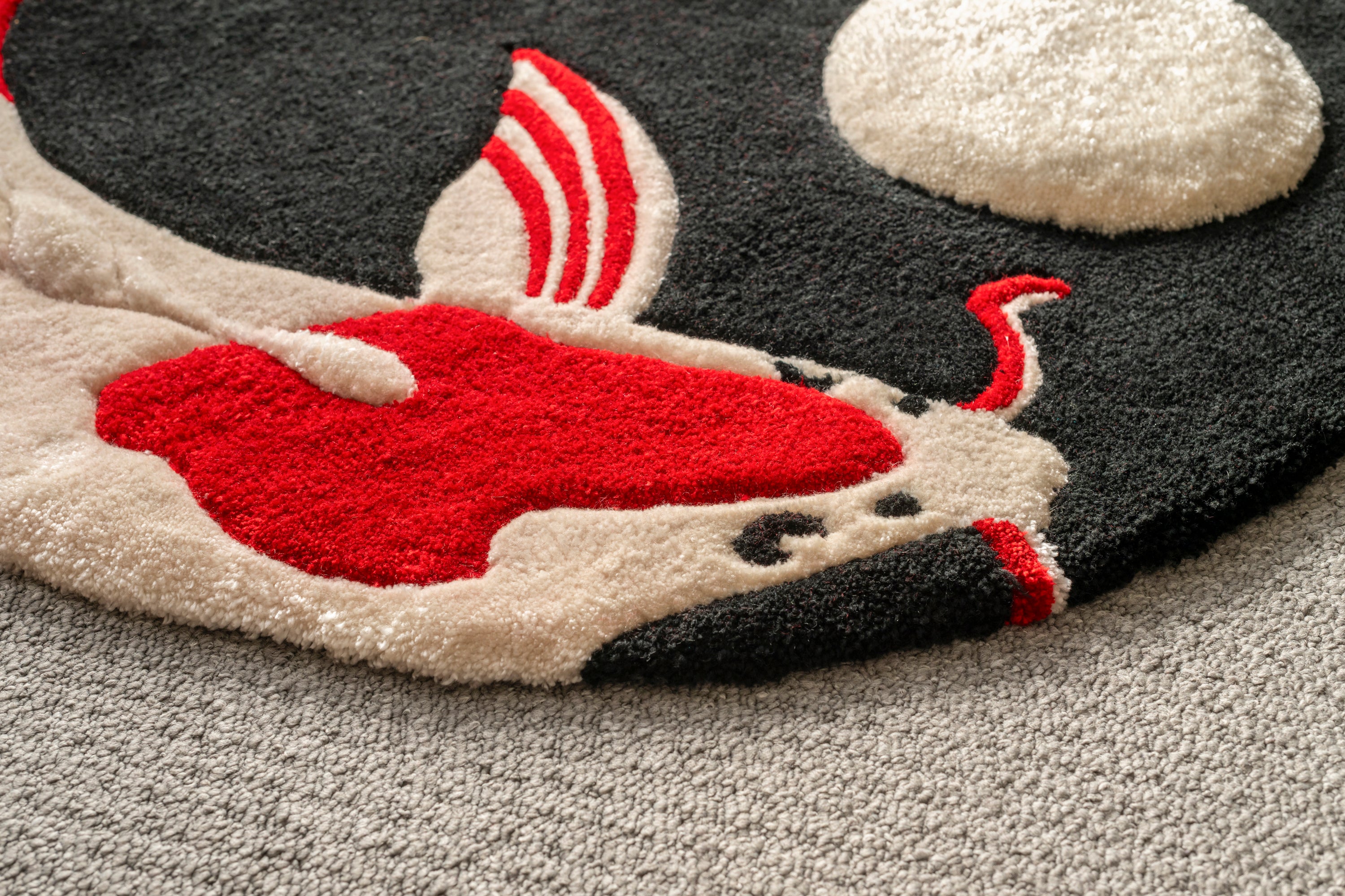 Close-up of the koi fish body and raised moon element on a handmade Japanese koi rug.