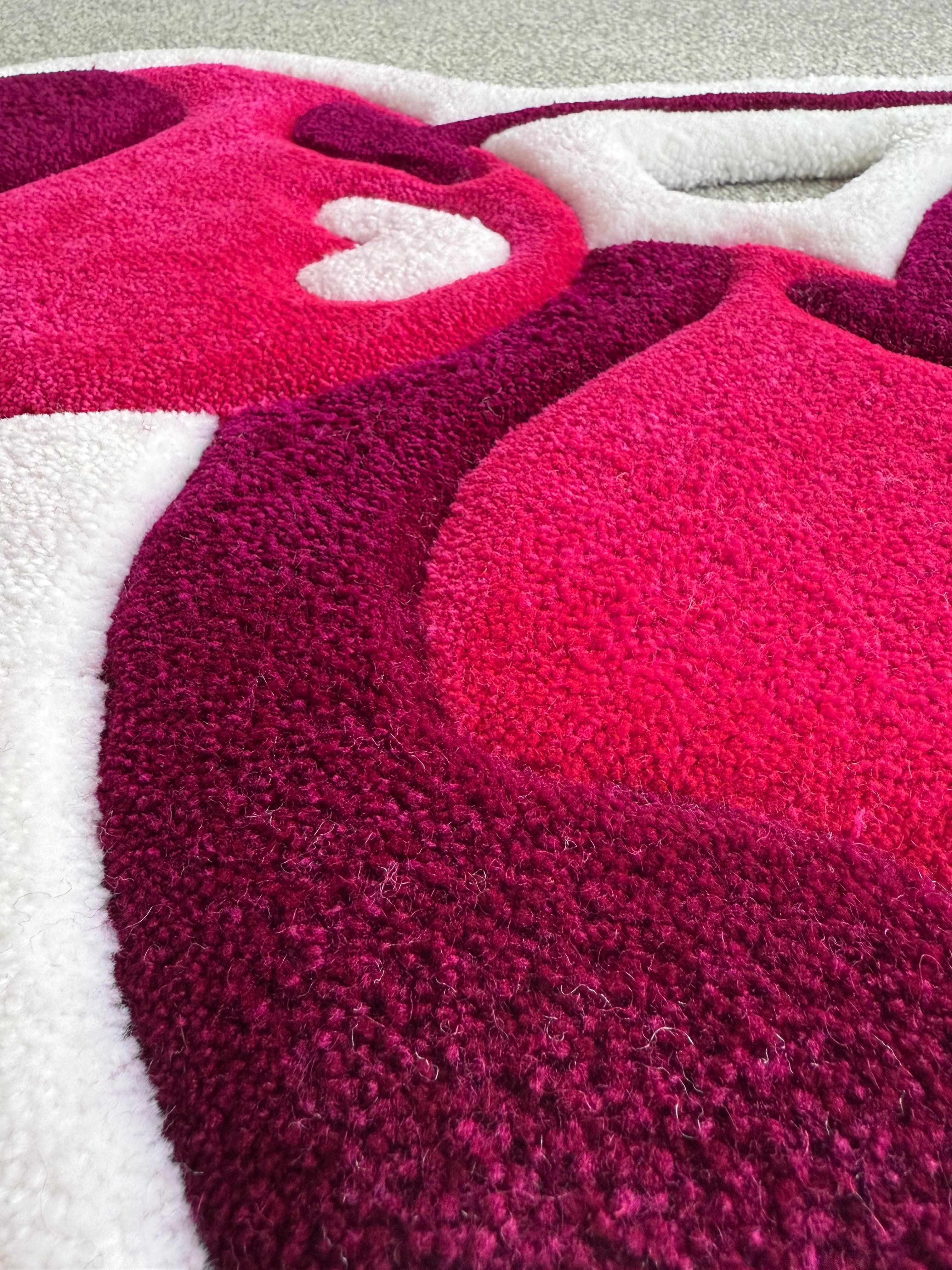 Close-up detail of a handmade pink cherry rug highlighting premium tufting, soft acrylic yarn and rich pink colour gradients.