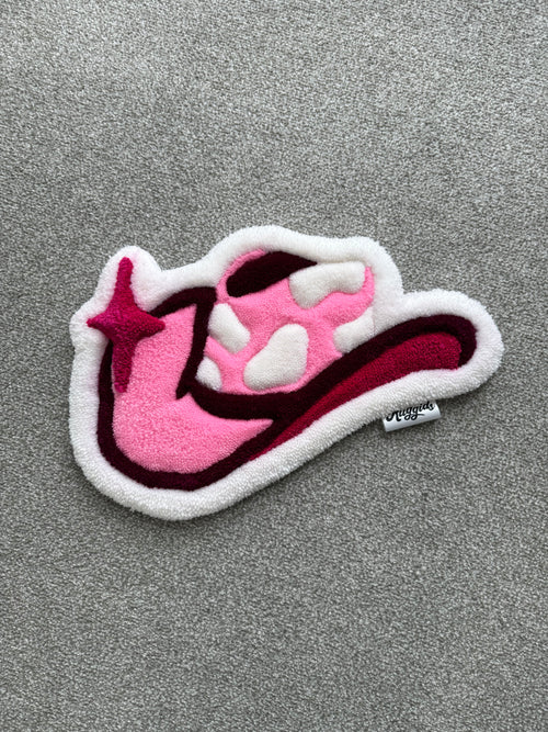 Handmade pink cowgirl hat rug featuring a western-inspired design with white cow print details and deep pink accents.