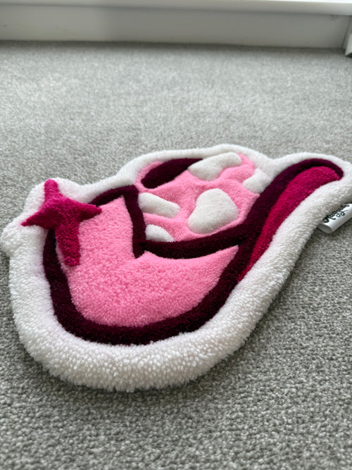 Low-angle view of a handmade pink cowgirl hat rug showcasing its low-pile texture, layered detailing and soft acrylic yarn.