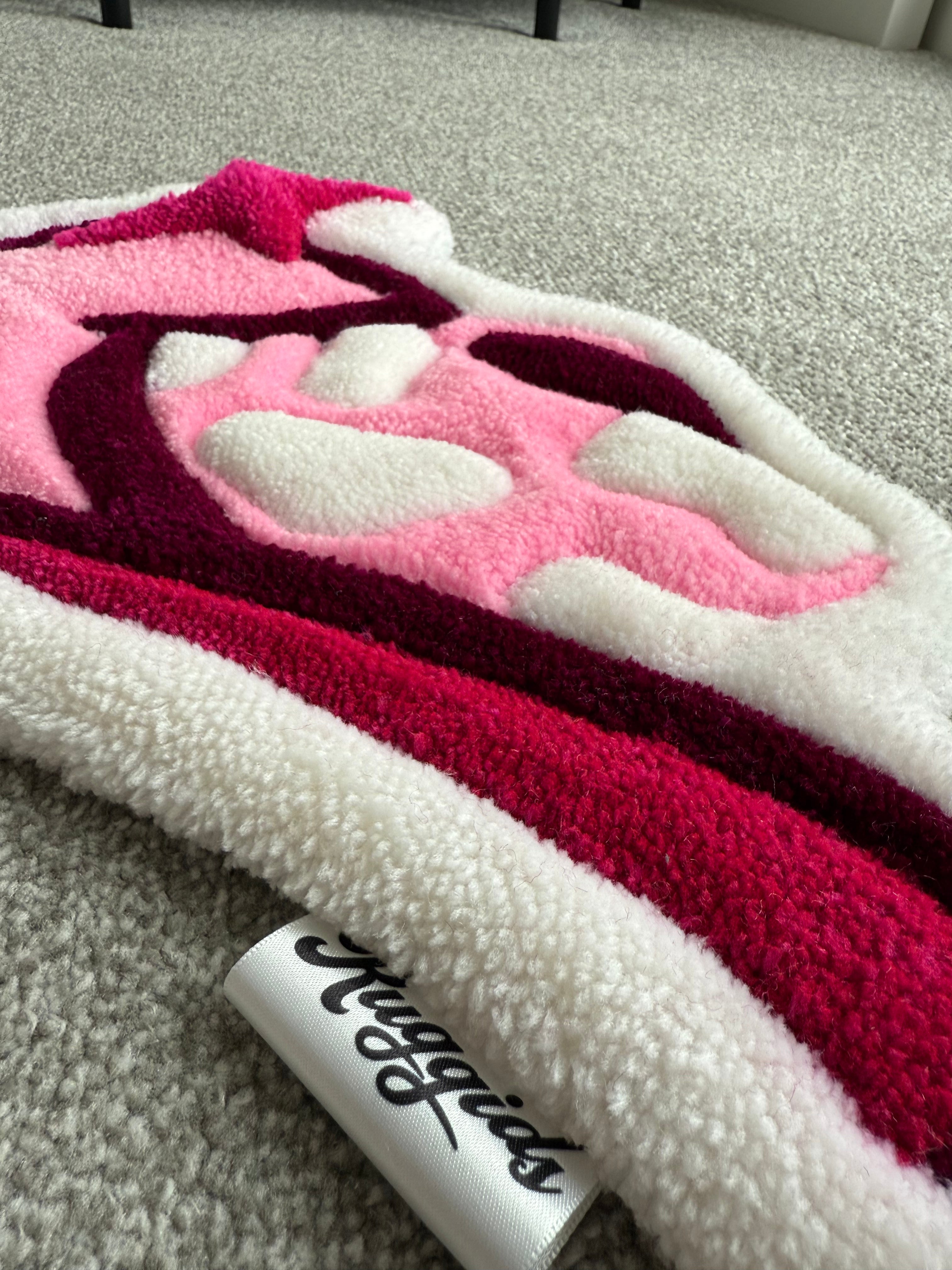 Close-up texture detail of a handmade pink cowgirl hat rug showing premium tufting, soft acrylic yarn and raised cow print accents.