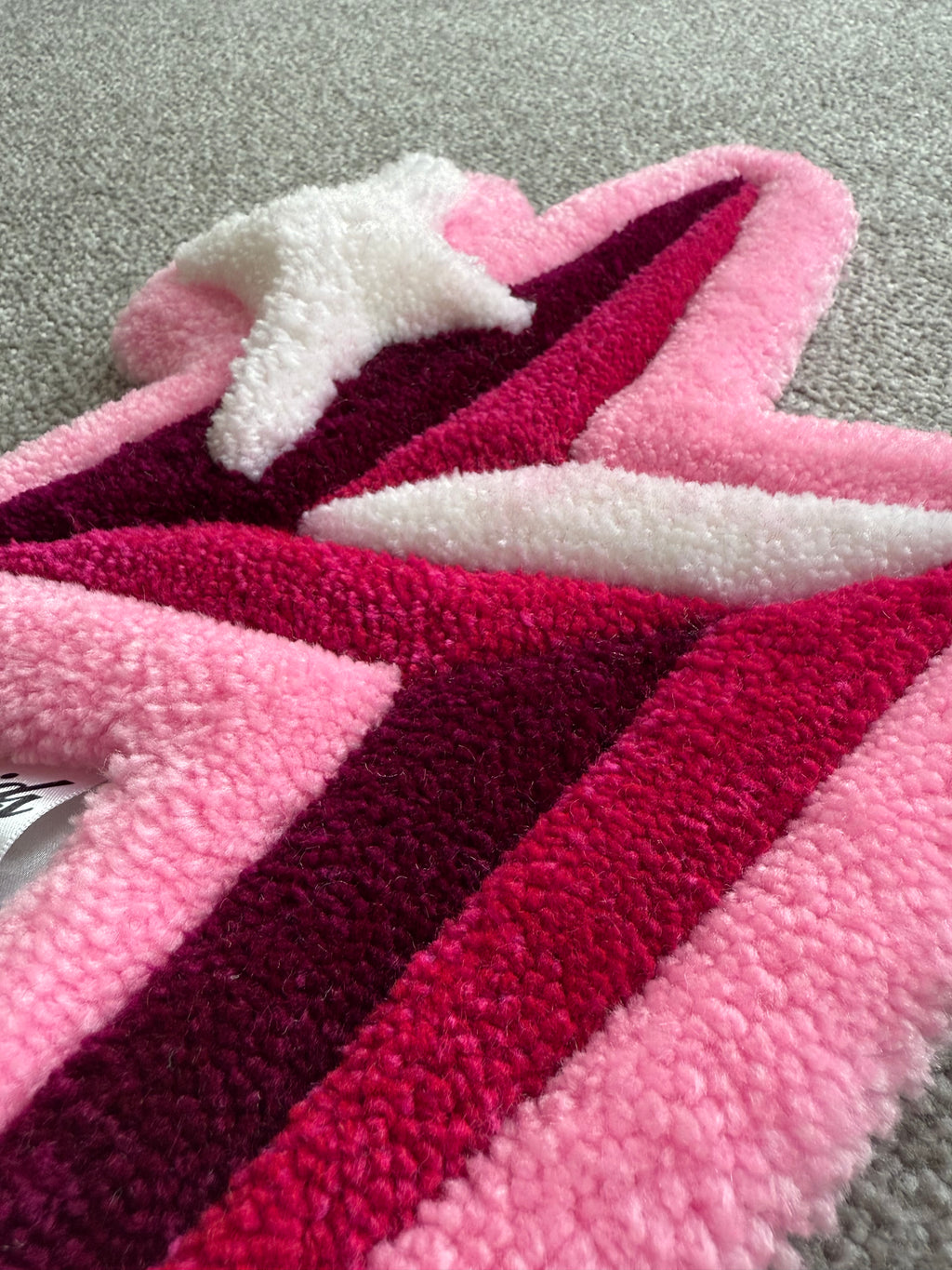 Close-up detail of a pink lightning bolt rug highlighting premium tufting, soft texture and layered pink colour tones.