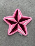 Handmade pink star rug featuring a bold five-point star design with layered pink, burgundy and white details.