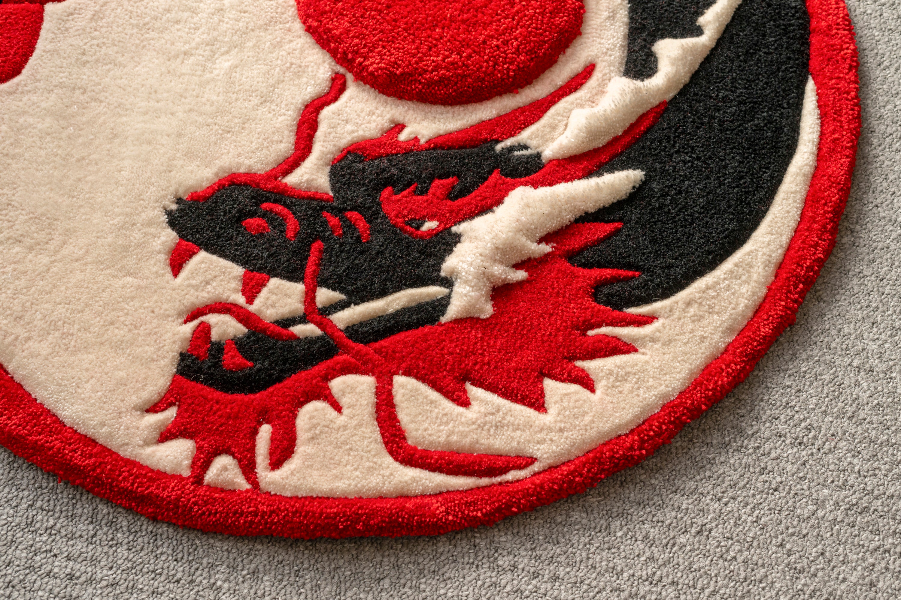Close-up of the dragon illustration on a handmade Japanese-inspired rug with bold black, cream and red tones.