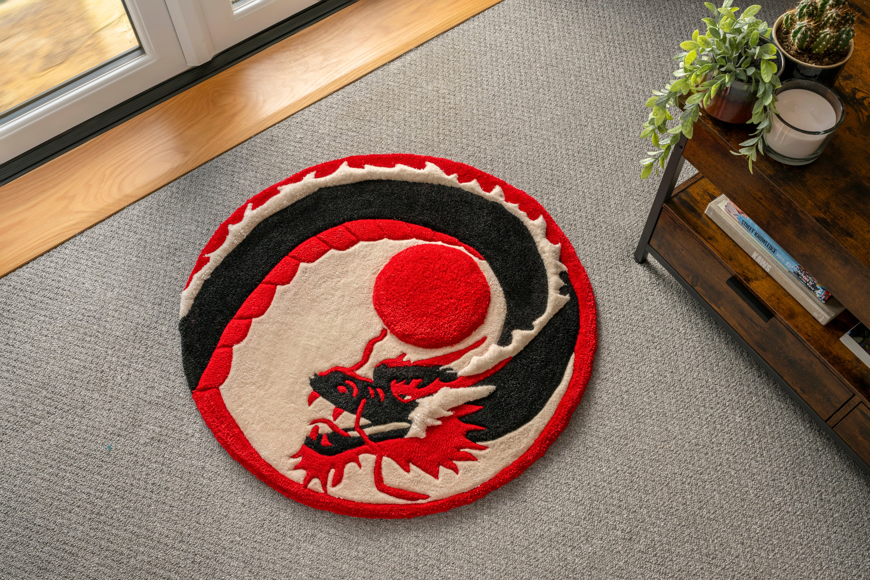 Handmade Japanese dragon rug featuring a black dragon coiled around a raised crimson sun in a circular red, black and cream design.