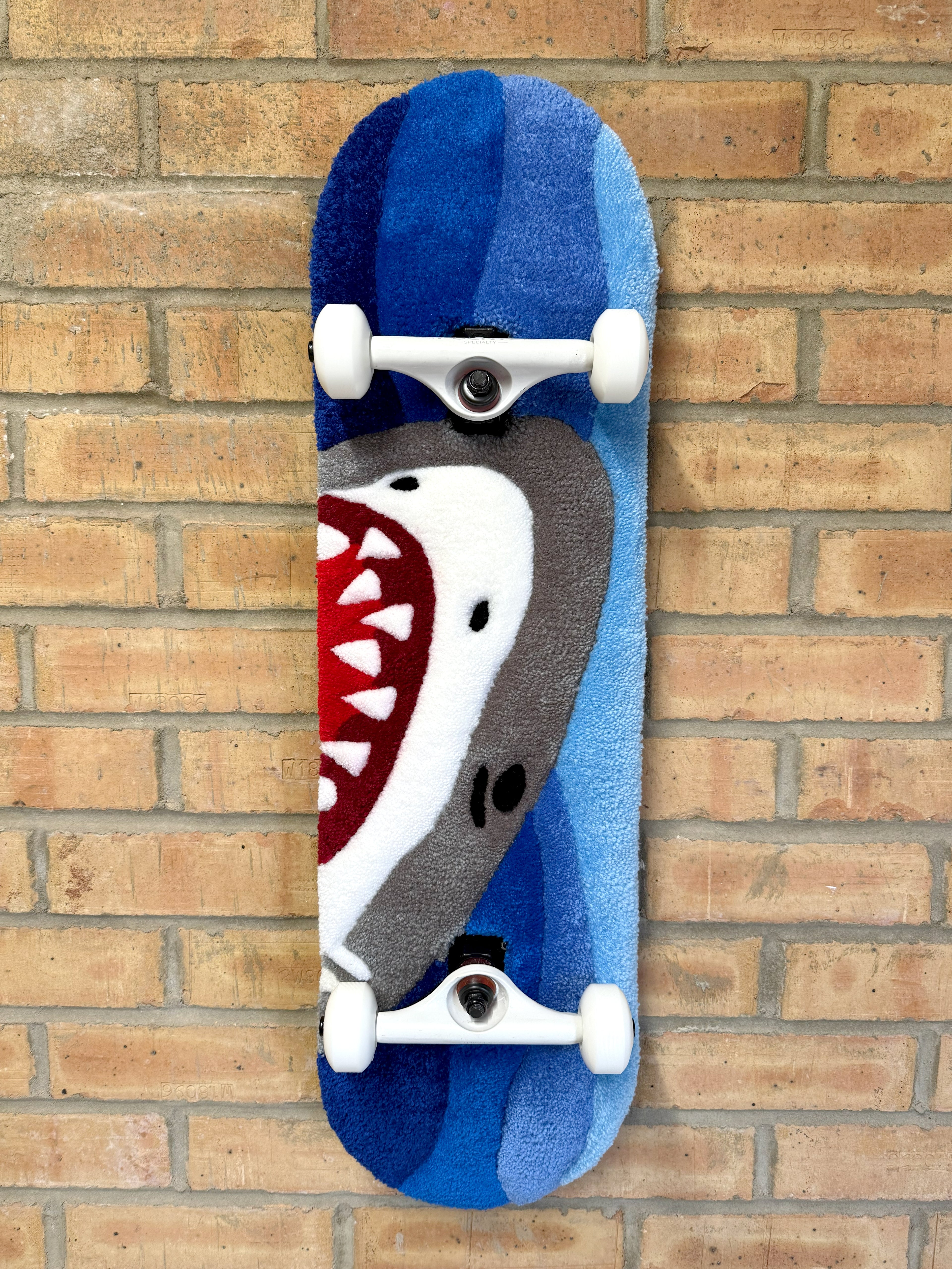 Handmade Shark Rugboard mounted on a skateboard deck featuring a shark graphic against layered blue ocean-inspired tones