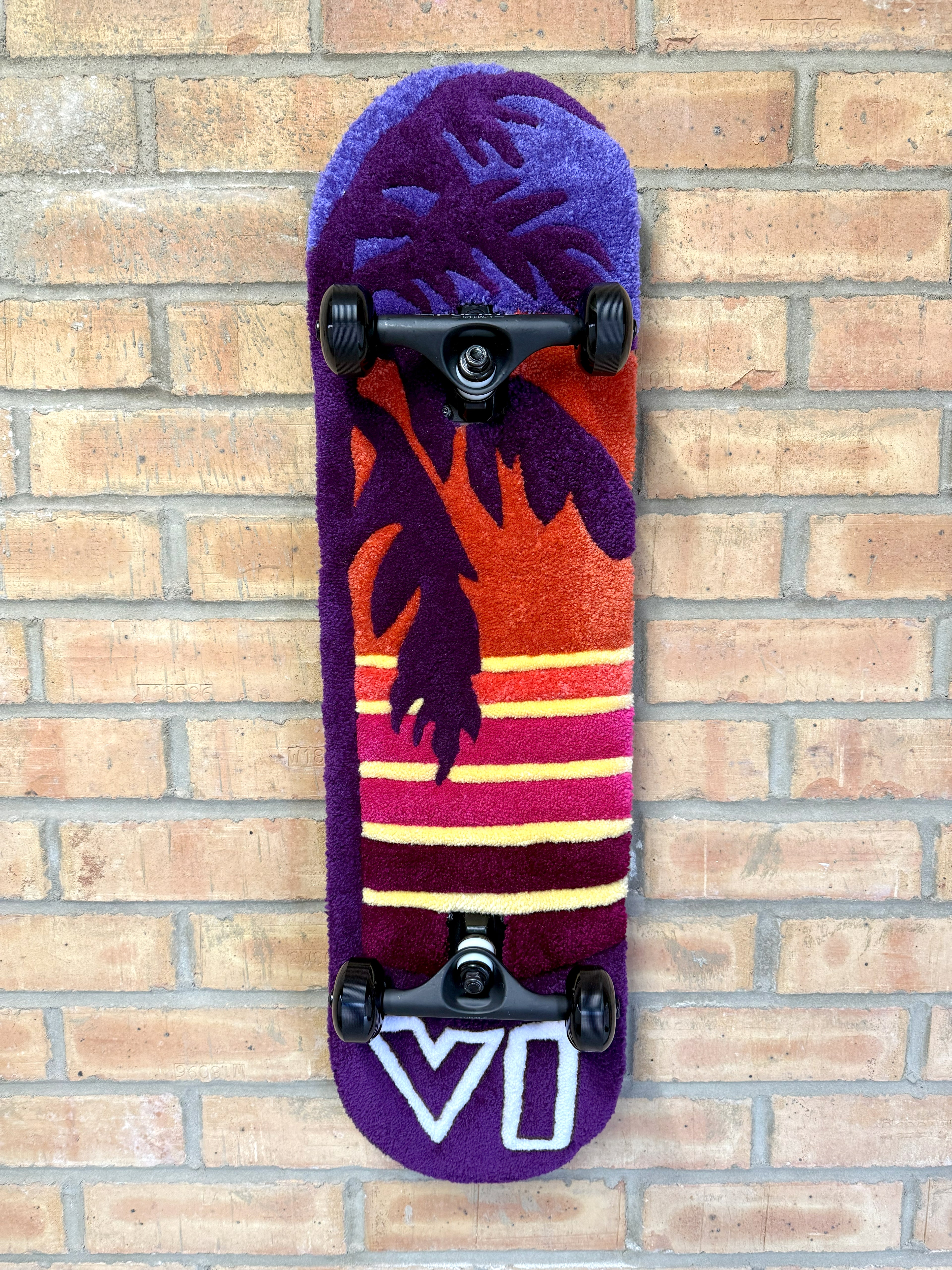 Handmade Vice Sunset Rugboard featuring a palm tree silhouette and retro sunset design mounted on a skateboard deck.