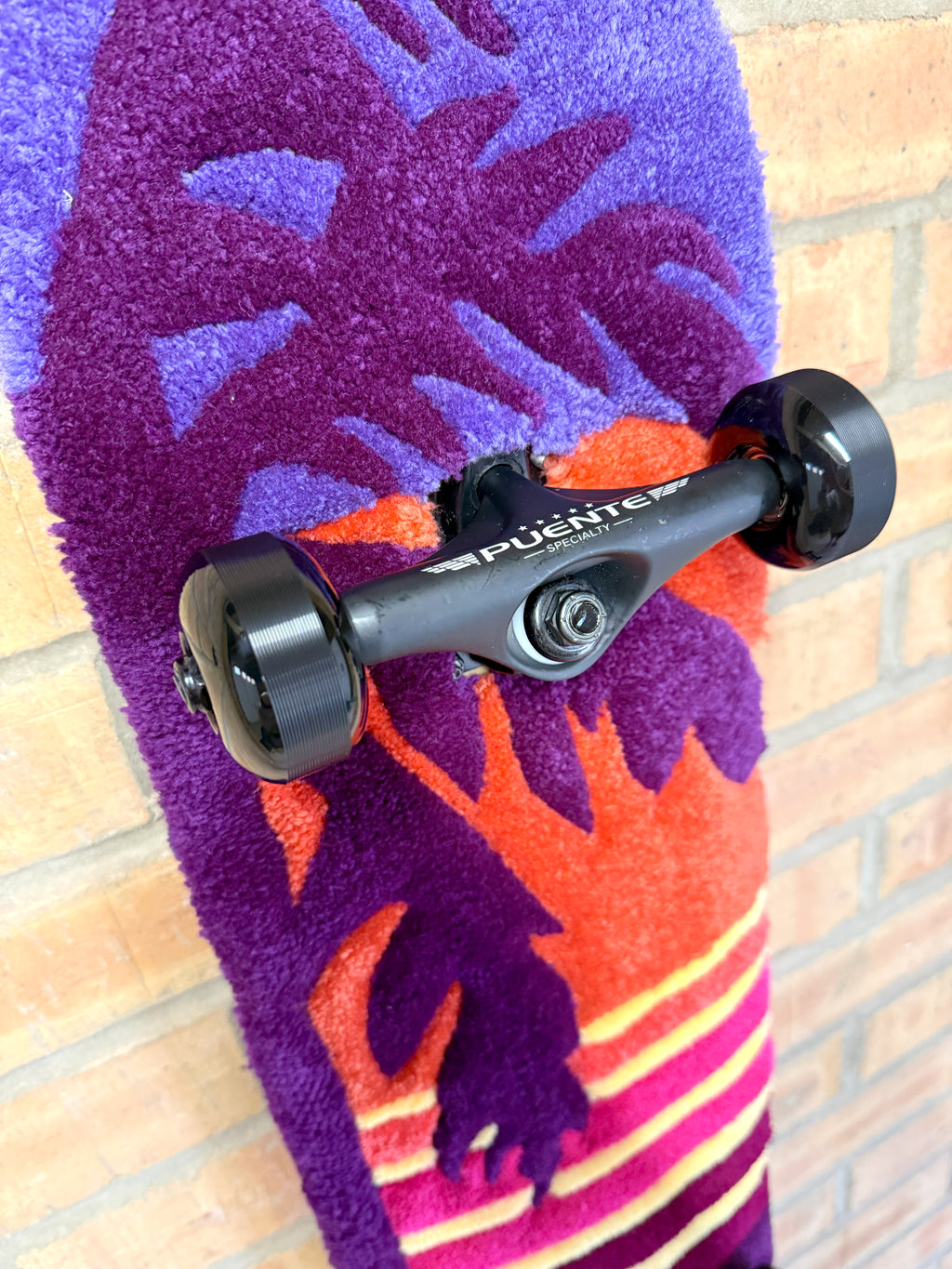 Close-up of the palm tree graphic on the Vice Sunset Rugboard with sunset-inspired colours and hand-tufted detailing.