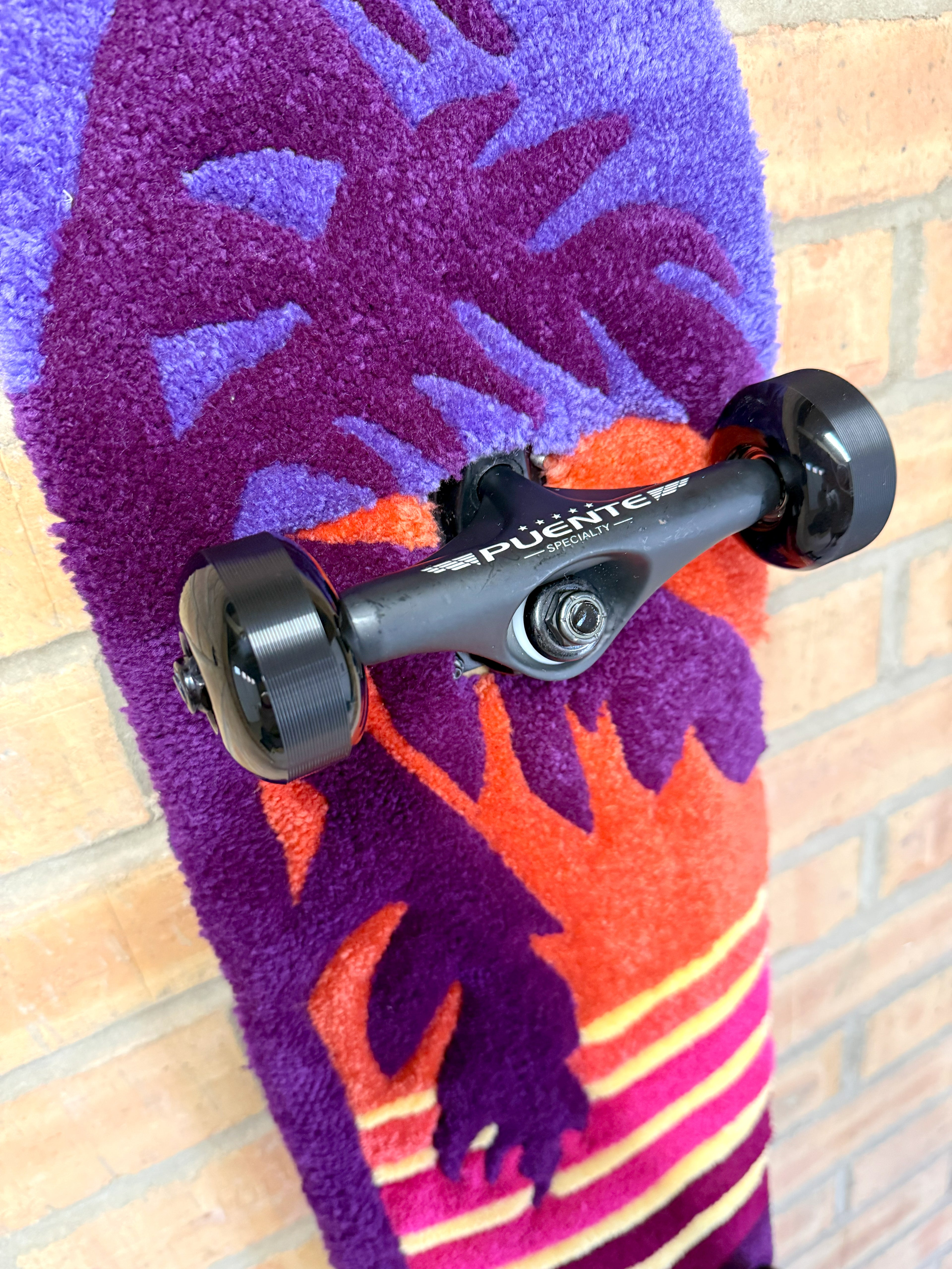 Close-up of the palm tree graphic on the Vice Sunset Rugboard with sunset-inspired colours and hand-tufted detailing.