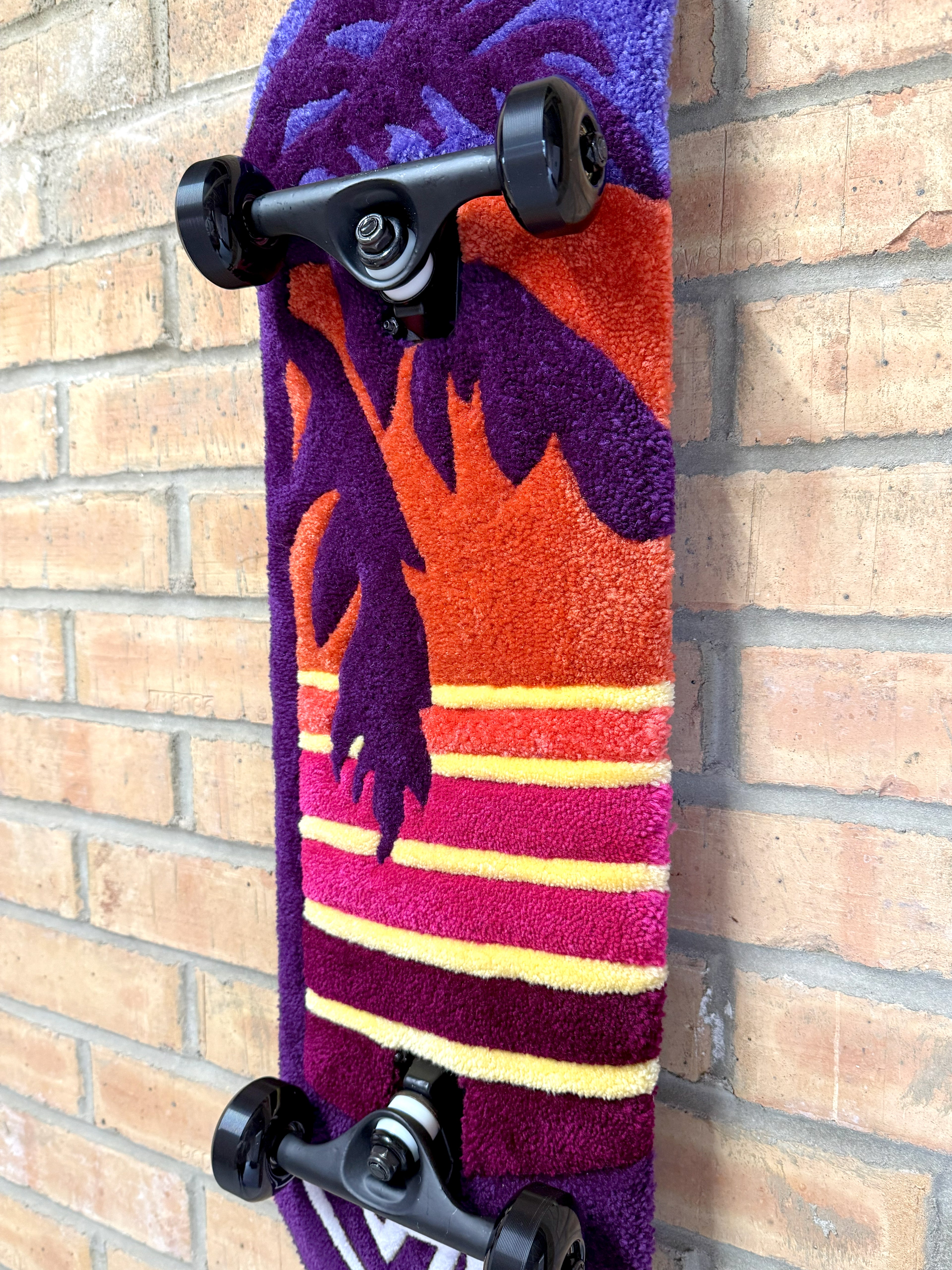 Side profile of the Vice Sunset Rugboard showing the layered sunset design, palm tree silhouette and skateboard deck depth.