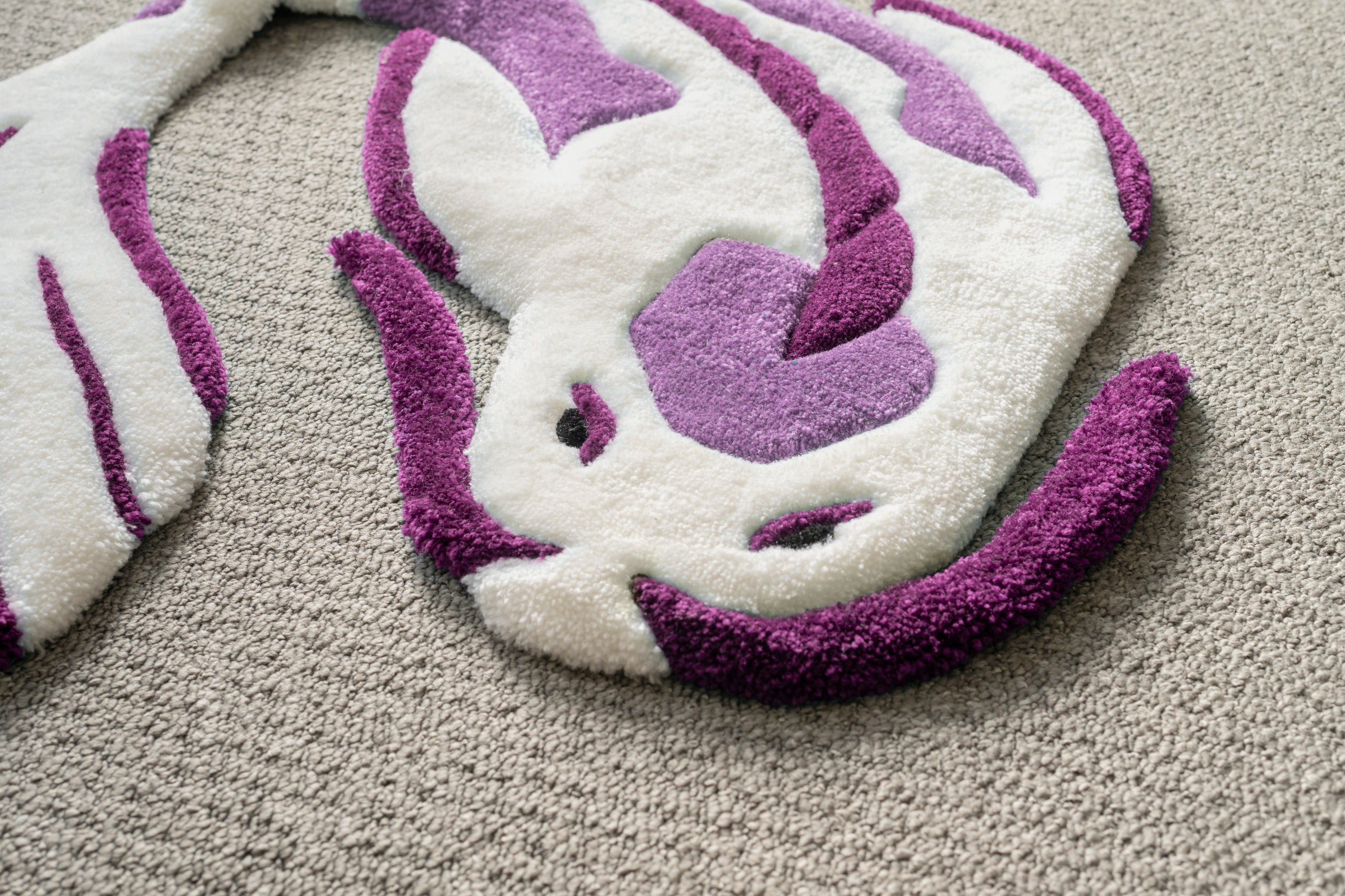 Detailed texture shot of a white and purple koi fish rug crafted from soft acrylic yarn with a smooth low-pile surface.