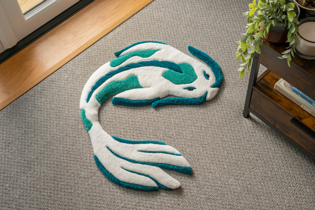 Handmade white and teal koi fish rug with flowing Japanese-inspired design and soft low-pile tufted texture.