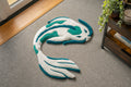 Handmade white and teal koi fish rug with flowing Japanese-inspired design and soft low-pile tufted texture.